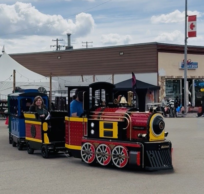 Close-up of the Northern Lights Express locomotive with a smiling rider aboard